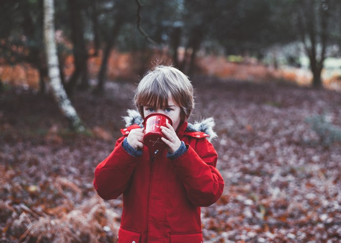 Boy in Red Coat Holding Red Enamel Mug