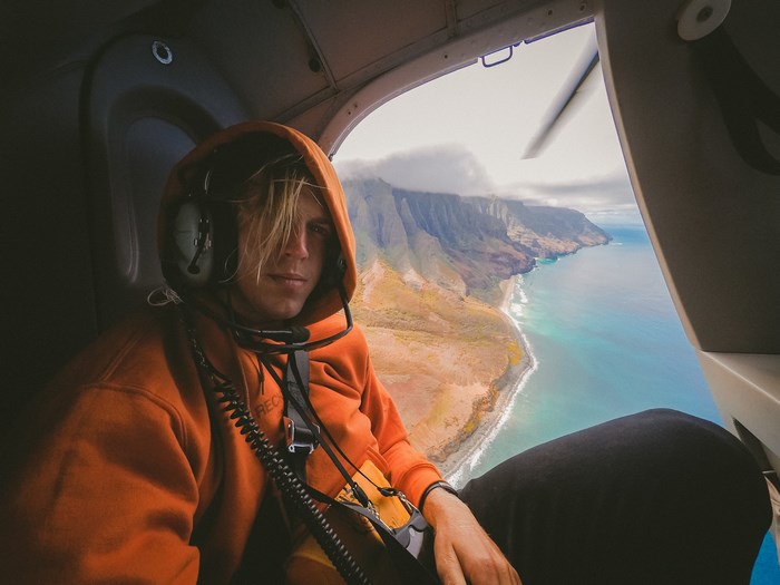 Man in helicopter flying over Kauai coast