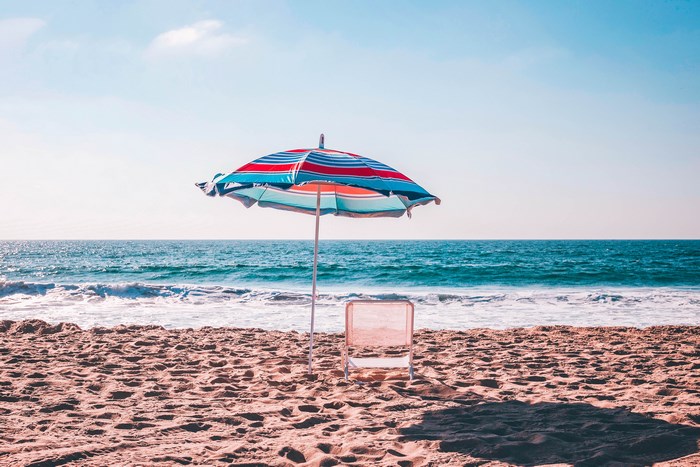 Beach umbrella and chair by the ocean shore