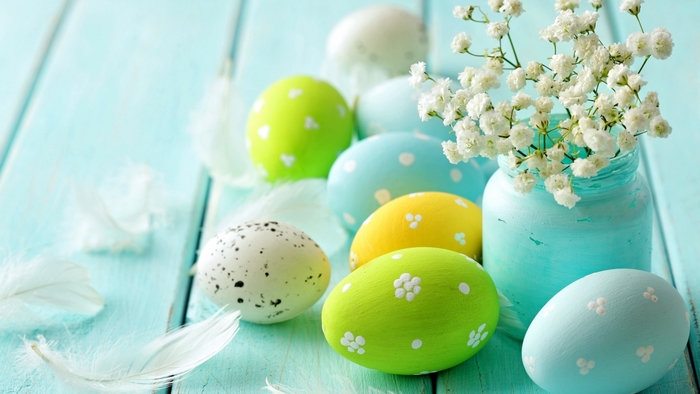 Easter eggs and flowers on a blue wooden table
