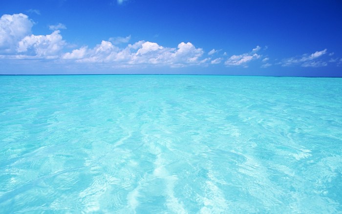 Turquoise ocean under a blue sky with clouds
