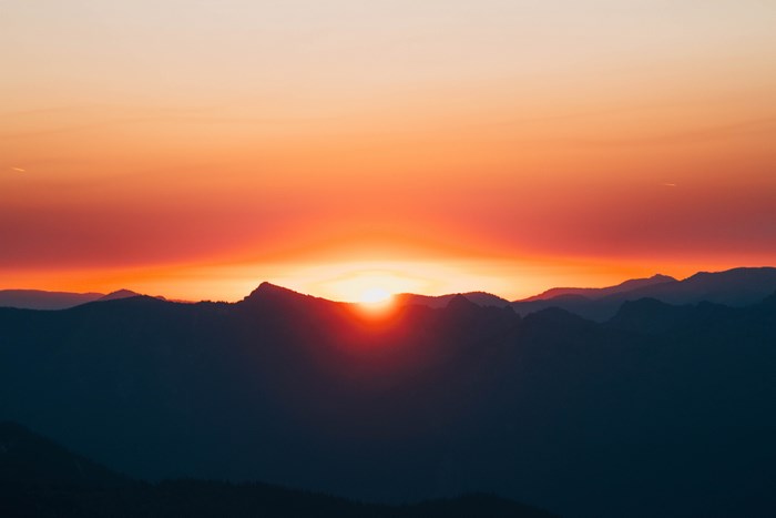 Sunset over silhouetted mountains in the Pacific Northwest