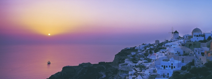 Santorini Greece sunset with sailboat and village