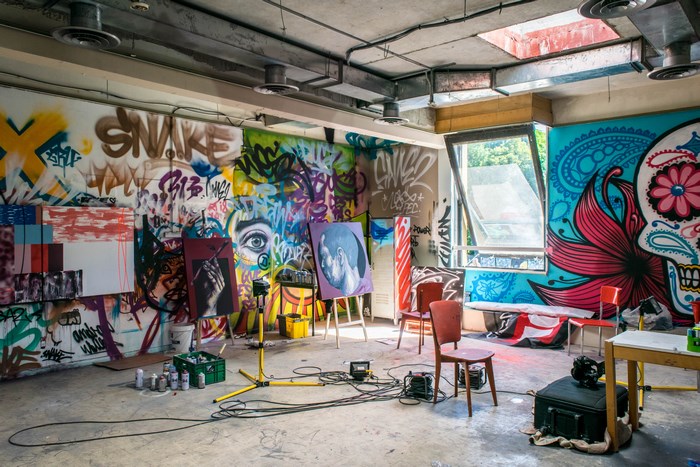 Graffiti art studio with paintings and spray paint cans