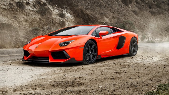 Orange Lamborghini Aventador on a dirt road
