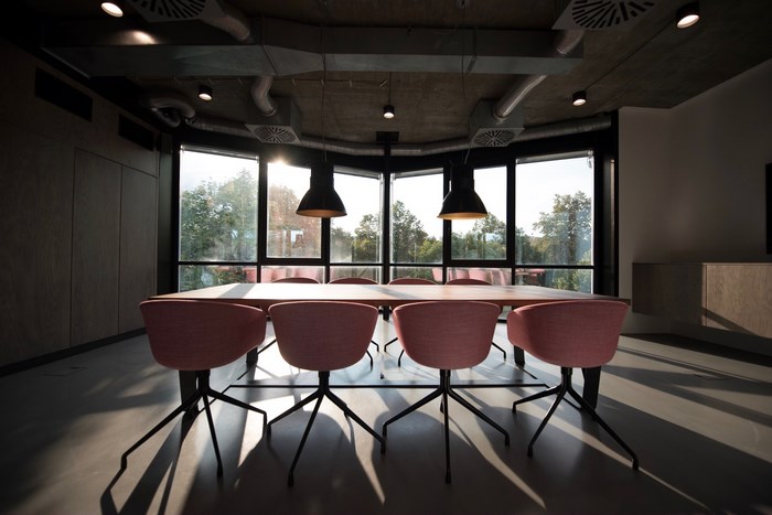 Modern meeting room with pink chairs and large windows