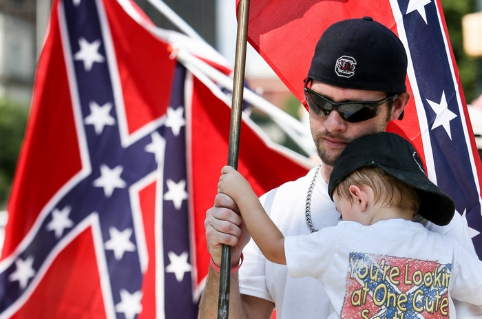 Man holding child with Confederate flags