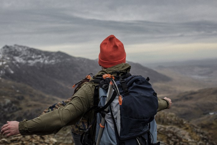Hikers with backpacks on a mountain valley