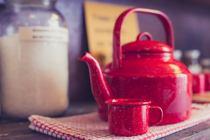Rustic Red Metal Teapot and Cup on Counter
