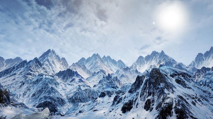 Snowy mountain range under a bright sun