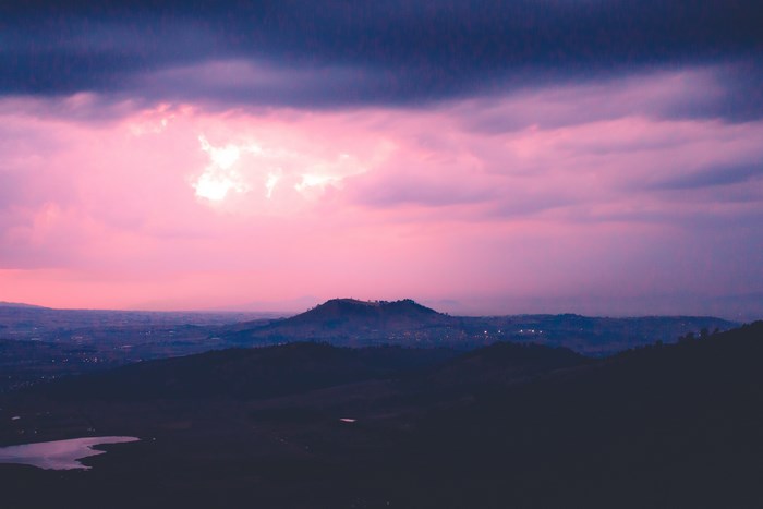 Purple and pink sky over hills at sunset