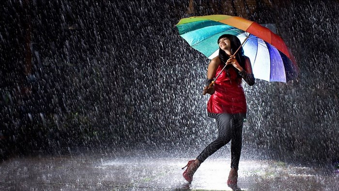 Woman with colorful umbrella in the rain