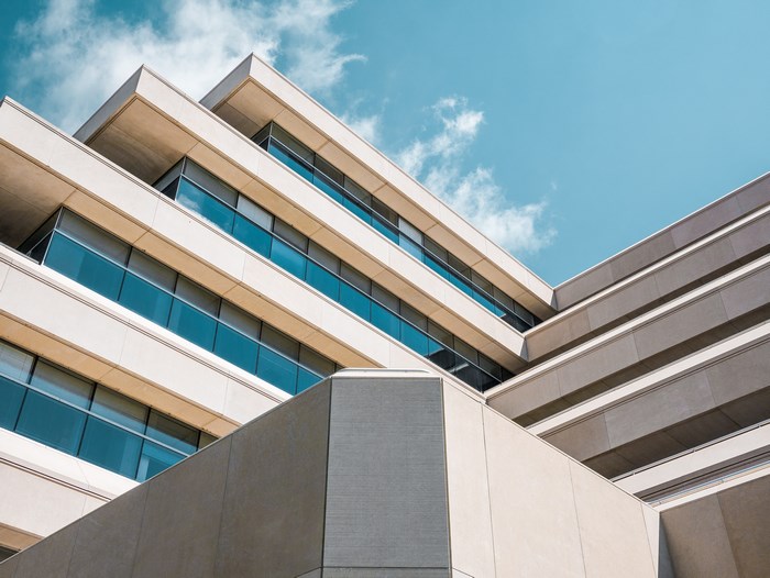 Modern concrete building with glass windows against blue sky