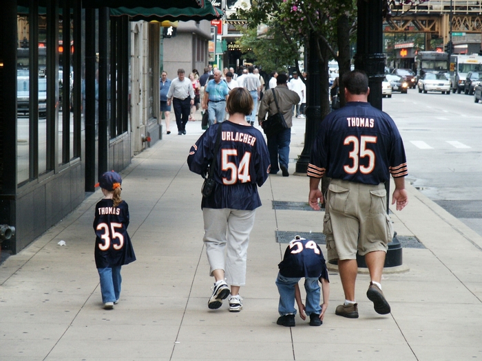 Family in Chicago Bears jerseys walking on sidewalk