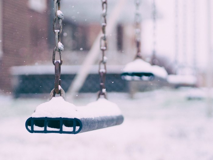 Snow covered swings on a winter day