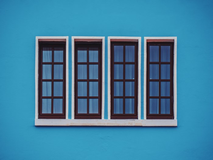 Four windows on a bright blue wall
