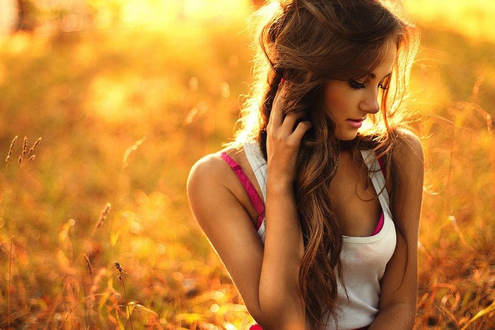 Young woman with long brown hair in a field