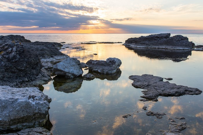 Rocky seaside with calm ocean during sunset