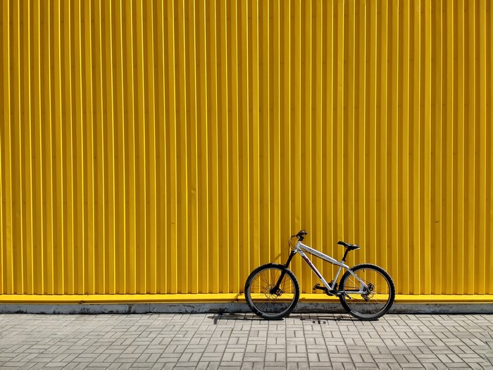 Bicycle leaning against a yellow corrugated wall