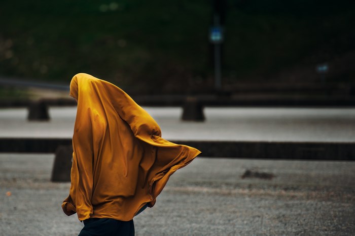 Woman in yellow hijab walking outdoors