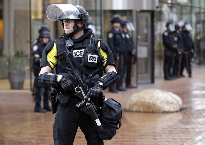 Police officers in riot gear with weapons