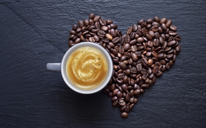 Coffee beans in heart shape with cup of coffee