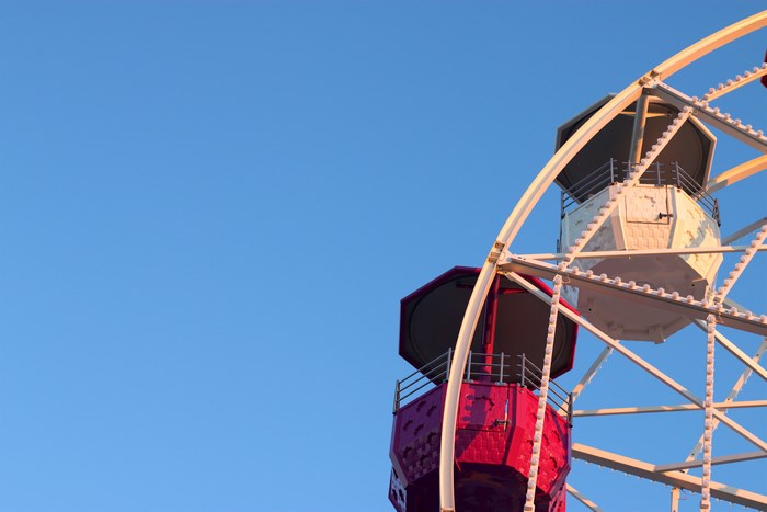Ferris wheel cabins against a clear blue sky