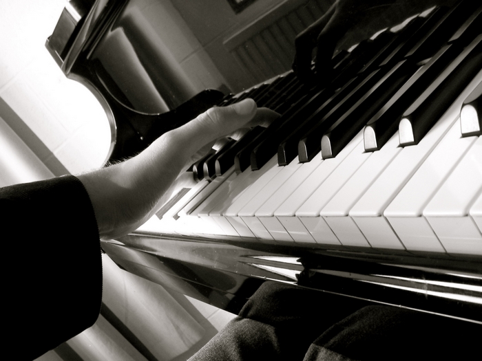 Close-up of a hand playing a grand piano