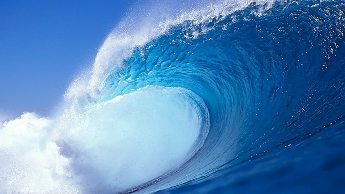 A large blue ocean wave crashing