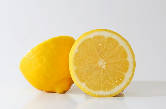 Two lemons, one whole and one sliced