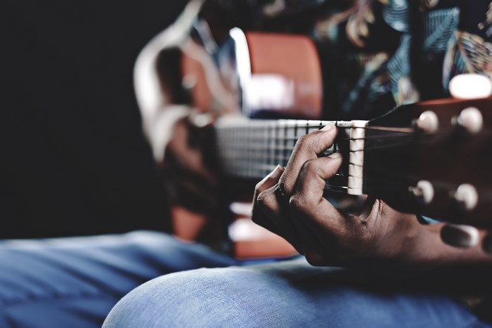 Close-up of a person playing an acoustic guitar