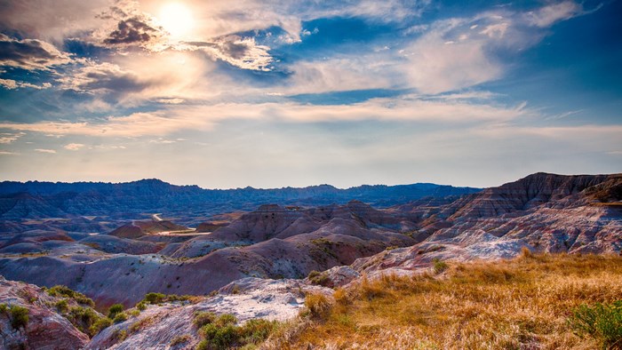 Badlands National Park landscape with sun and clouds