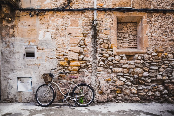 Old stone wall with a bicycle and a window