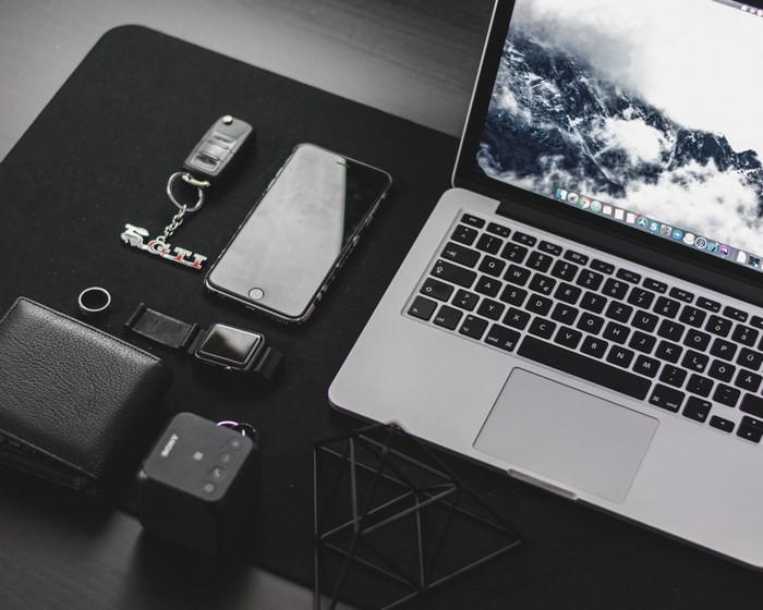 Modern workspace with laptop, phone, and accessories