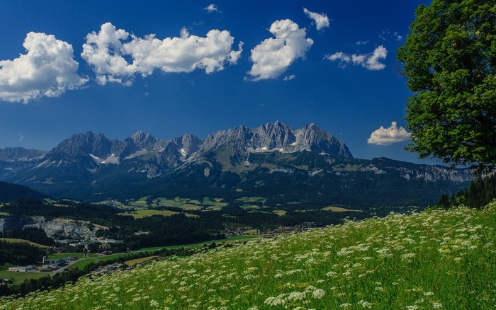 Mountain range with clouds and green meadow