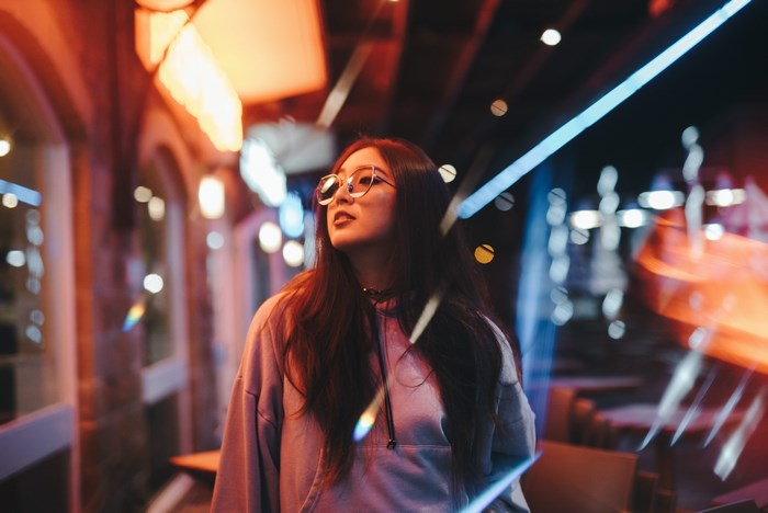 Young Woman with Glasses in Neon Urban Night