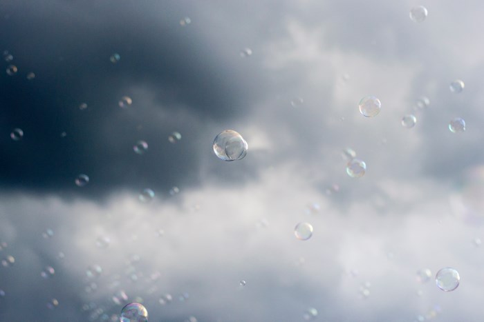 Bubbles floating against a dark and cloudy sky