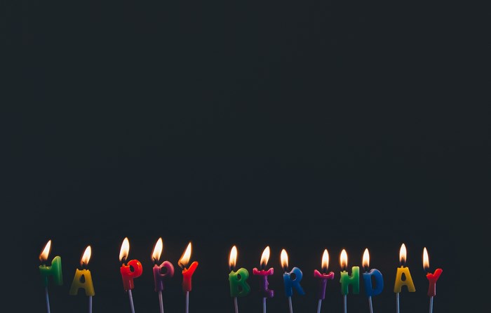 Colorful Happy Birthday Candles Lit in Dark