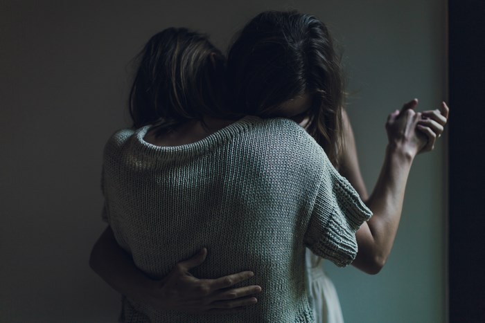 Two women sharing an emotional dance embrace