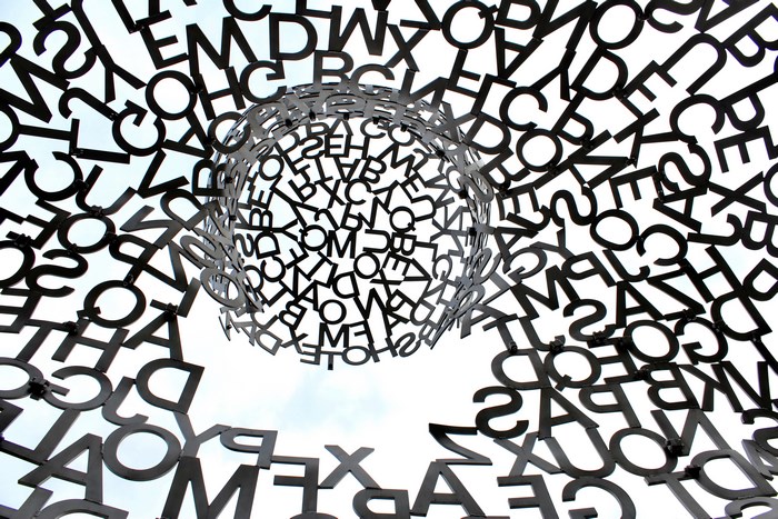 Abstract sculpture of letters against the sky