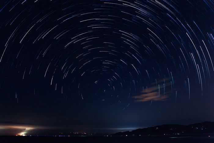 Star trails over the sea at night