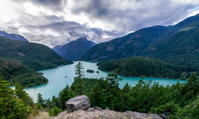 Turquoise Mountain Lake Surrounded by Forest and Peaks