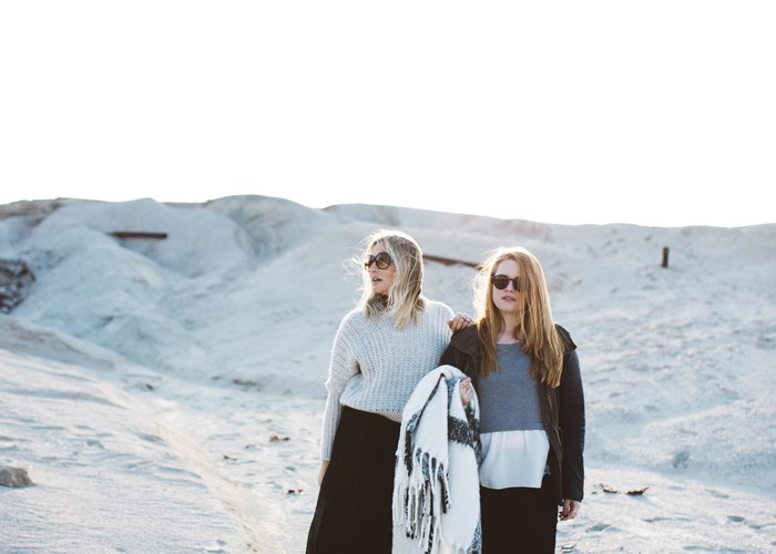 Two women with sunglasses in a sandy landscape