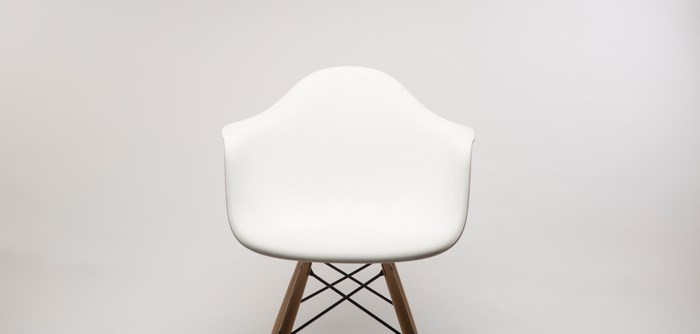 White Eames chair with wooden legs on a seamless background