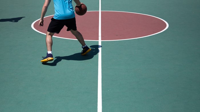 Man dribbling a basketball on a court