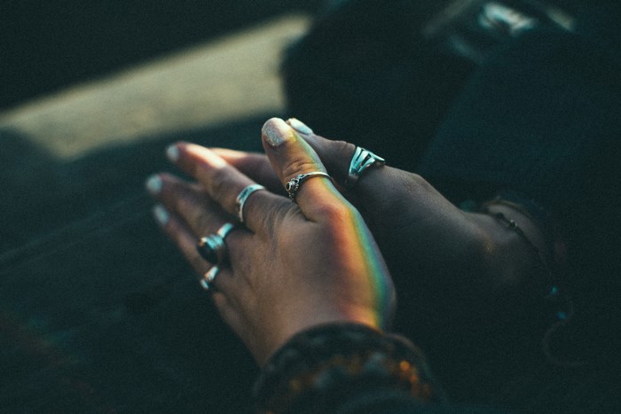 Hands with rings and rainbow light