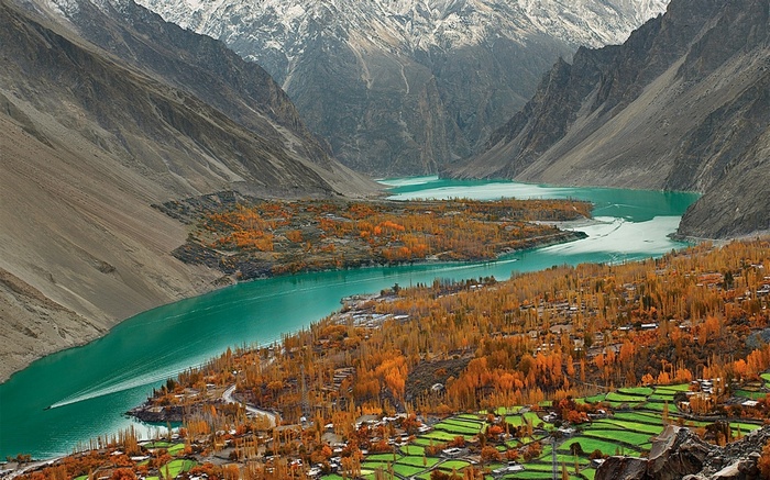 Turquoise lake and autumn trees in a mountain valley