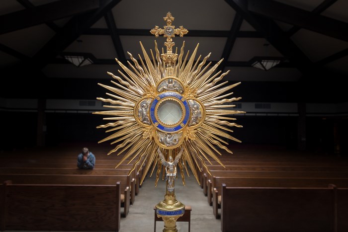 Golden Monstrance in a Church with a Praying Person