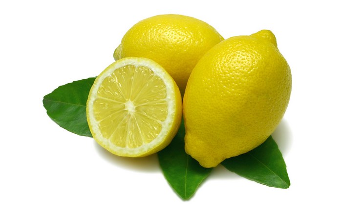 Three lemons and green leaves on white background