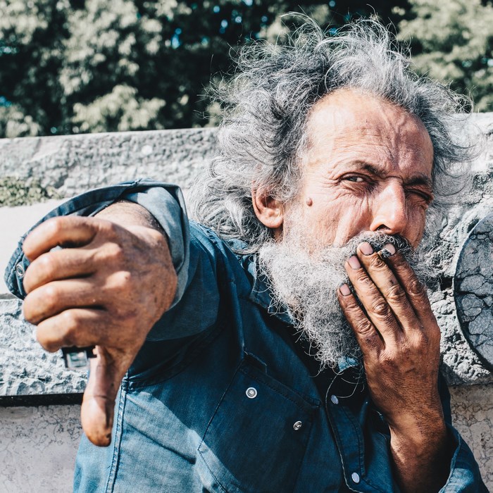 Elderly man with grey hair giving thumbs down